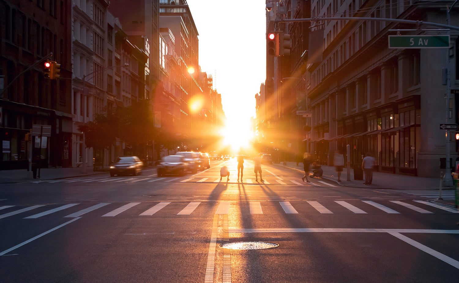 sun shining between tall building and through city streets